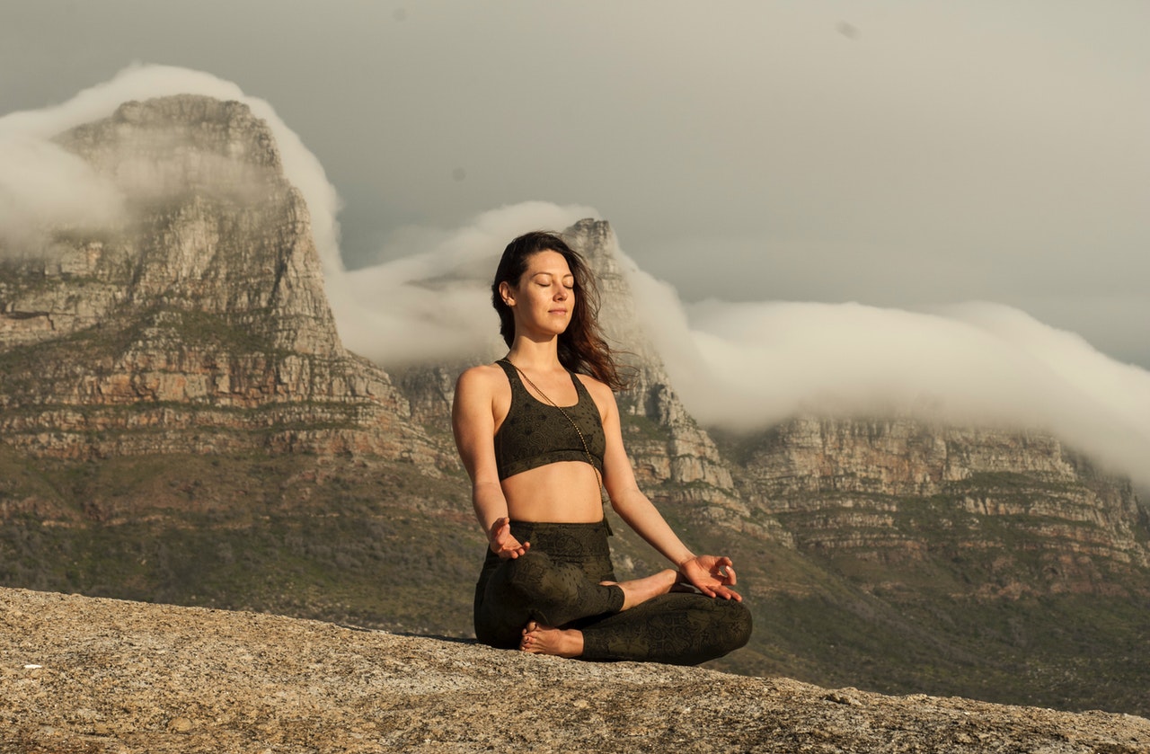 Girl in a mountain setting doing meditation